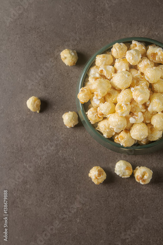 Sweet popcorn in a bowl. Gray background. Watch a movie.
