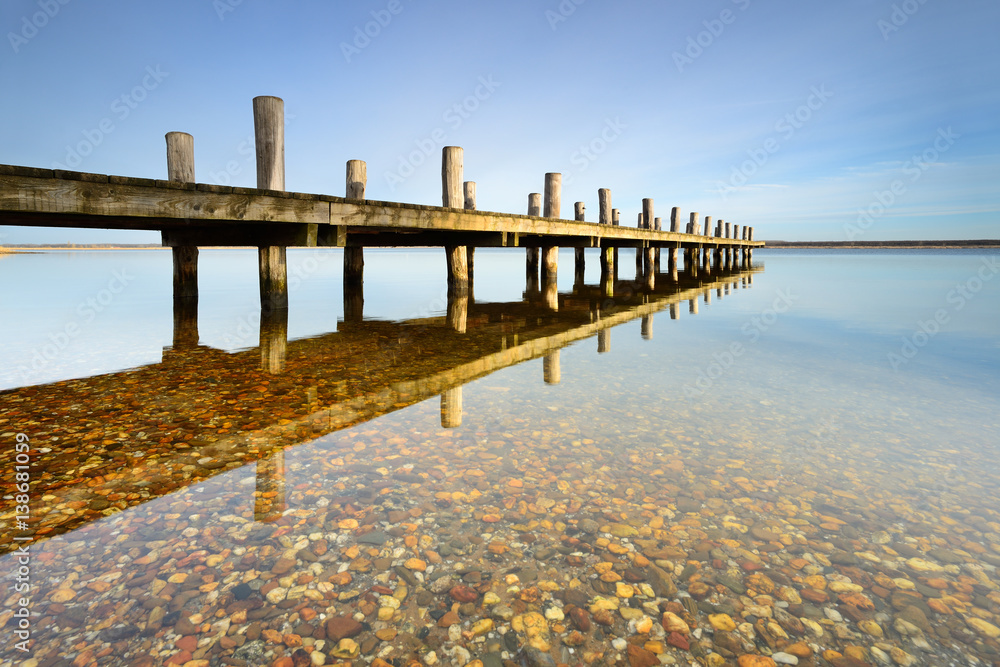 Obraz premium Calm clear lake with wooden pier