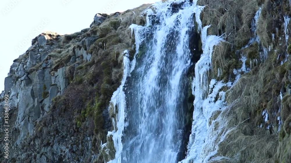Iceland waterfall in winter with frozen spray ice and snow Iceland waterfall in winter with frozen spray ice and snow