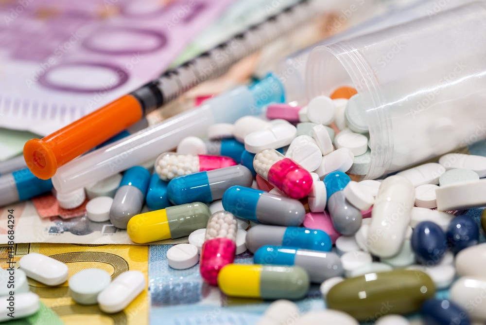 pills with syringe above euro bills. Medicine cost. pills with syringe above euro bills. Medicine cost.