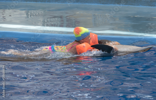 Little girl swim on dolphin