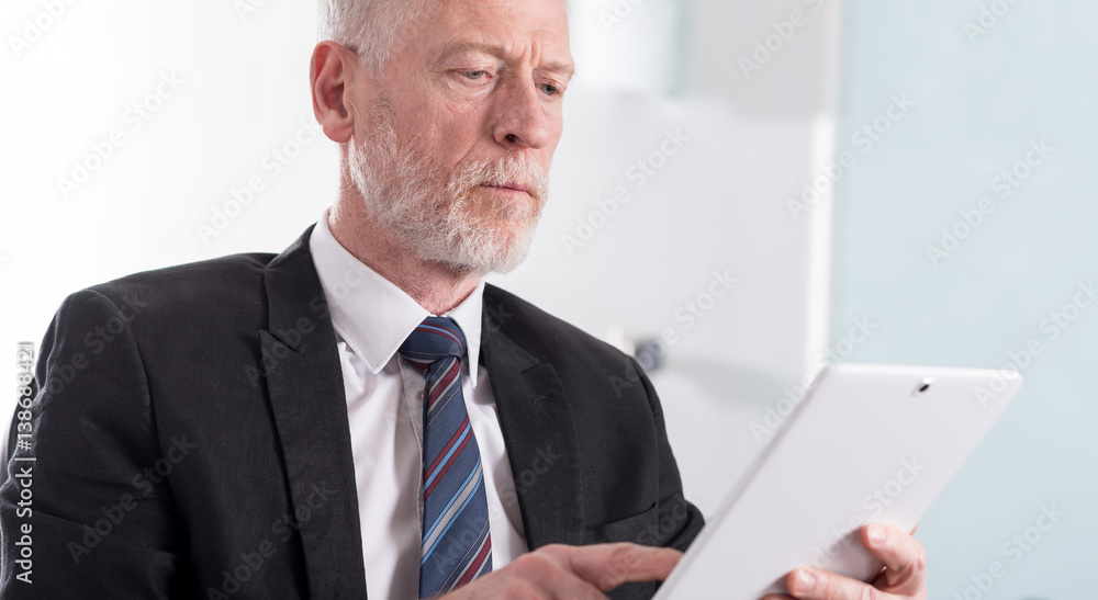 Portrait of senior businessman working on tablet Portrait of senior businessman working on tablet