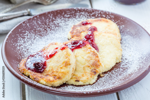 Homemade Cottage Cheese Pancakes with Berry Sauce for Breakfast on White Wooden Background, Horizontal View