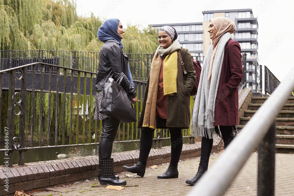 British Muslim Female Friends Meeting In Urban Environment