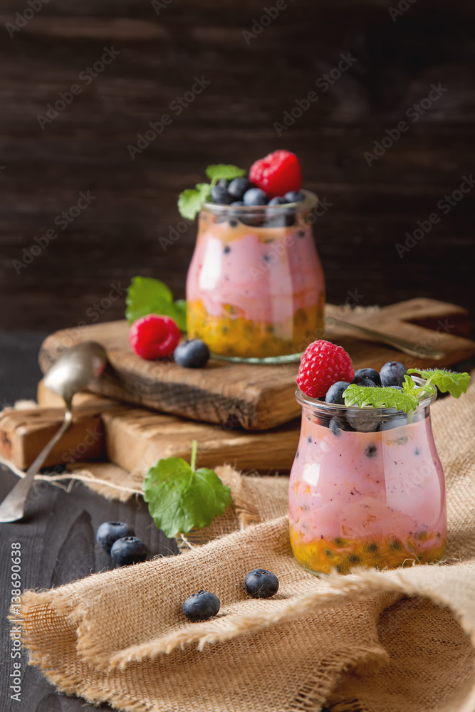 Fresh homemade yogurt in a glass jar with blueberries, raspberri