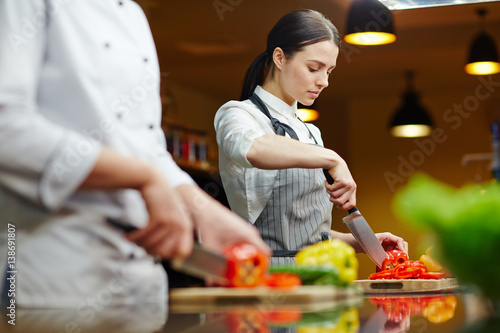 Photos Restaurant worker cutting fresh pepper for salad