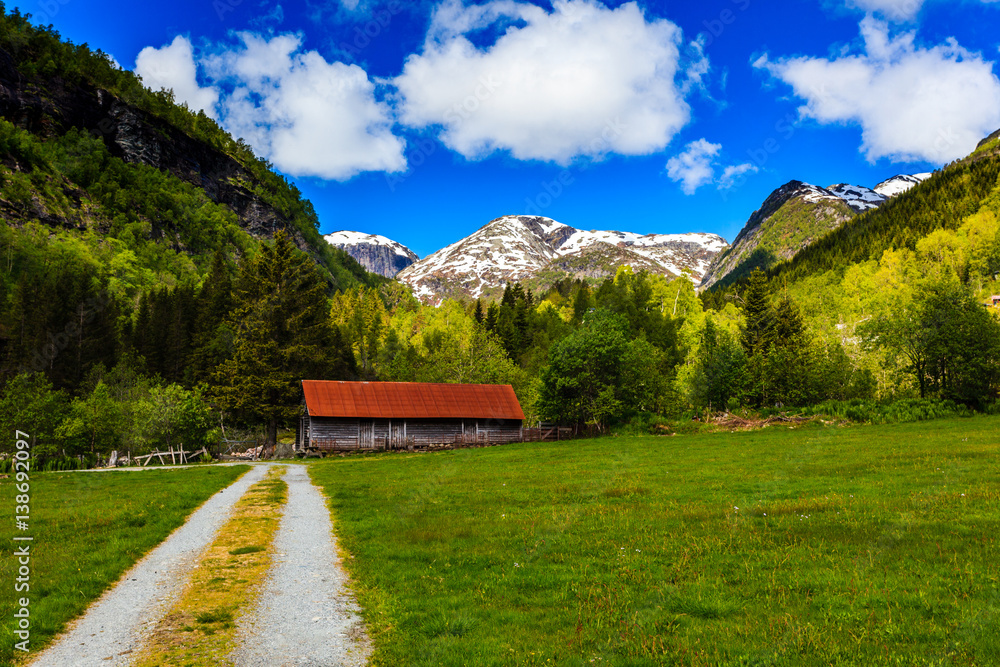 Beautiful natural landscape with green meadows, snow-capped mountains and blue sky, Kvam in Hardanger, NorwayKvam,