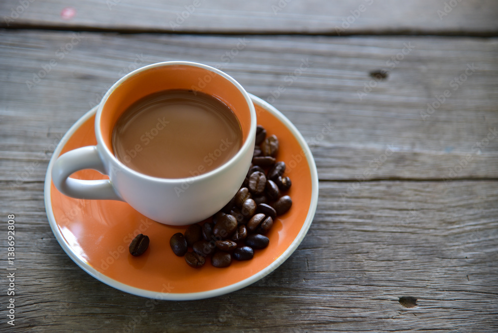 Fototapeta premium A Cup coffee and beans on wooden 