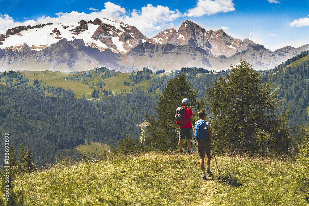 Hikers in beautiful landscape of Dolomites Italy - Hiking in the mountains. Pair of hickers with bacpack