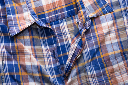 Textile texture of the checkered shirt, closeup the fastener useful as background
