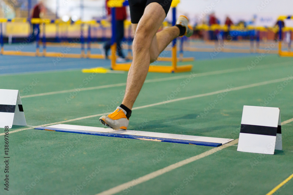 Sportsman landing his leg on fault line of board before taking off in long jump or tripple jump competition