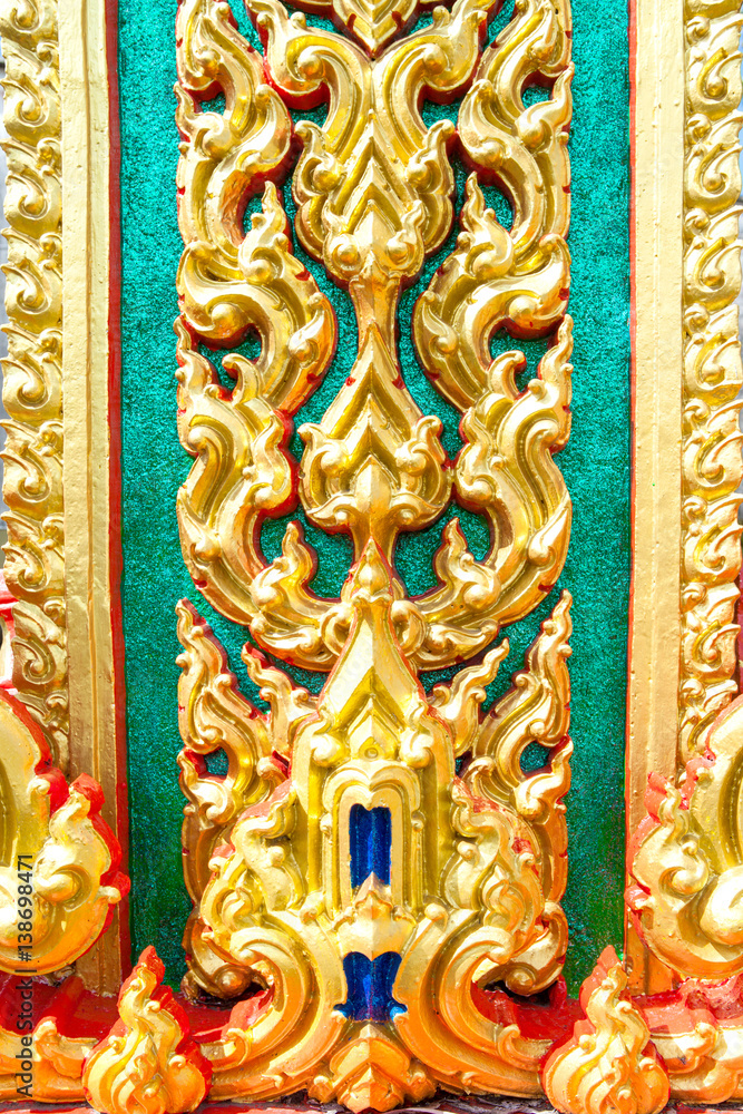Gold Thai art of Sculpture on the wall of temple in Thailand.