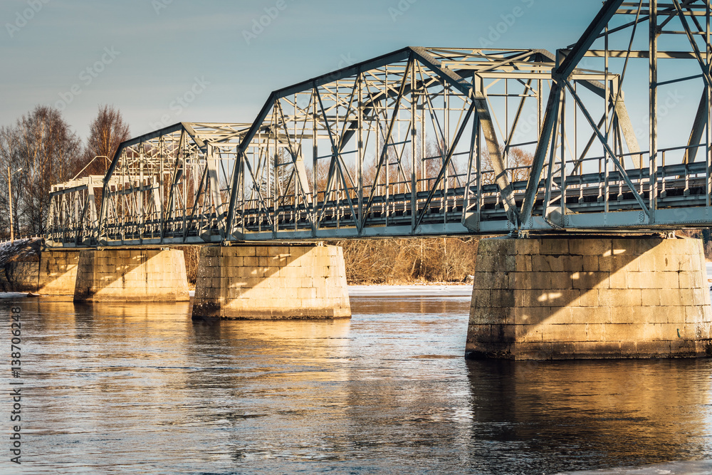 Naklejka premium Bridge over a river in Näs Sweden on a sunny winter day. Steel Construction with foundations of stone