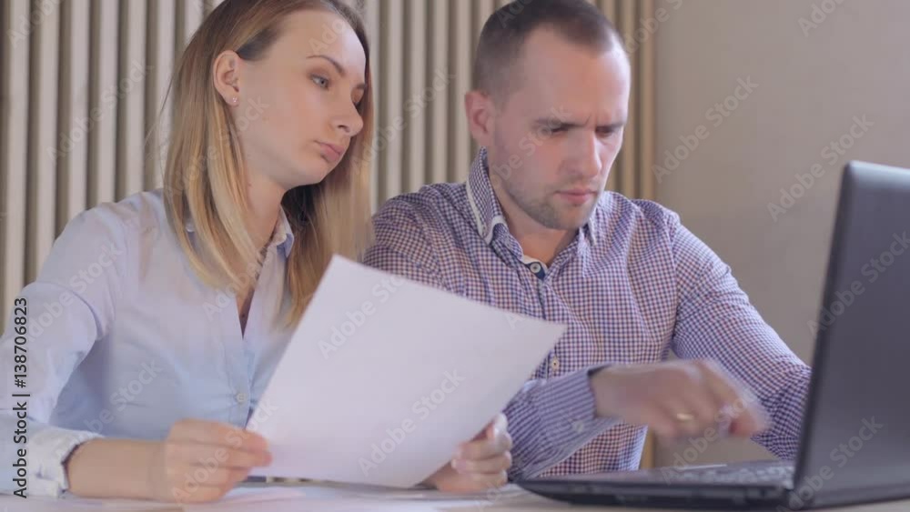 Business partners with papers and a computer Business partners with papers and a computer