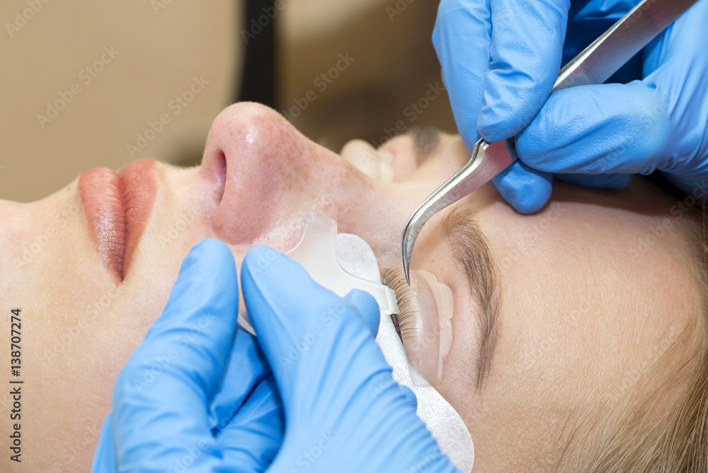 Woman on the procedure for eyelash extensions, eyelashes lamination Woman on the procedure for eyelash extensions, eyelashes lamination