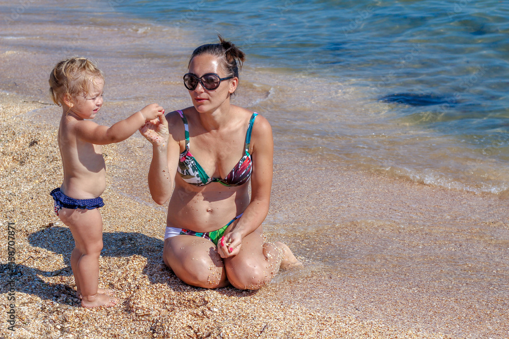 Little baby girl with mother on beach Little baby girl with mother on beach