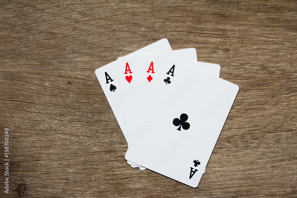 Four card of ace on wooden background