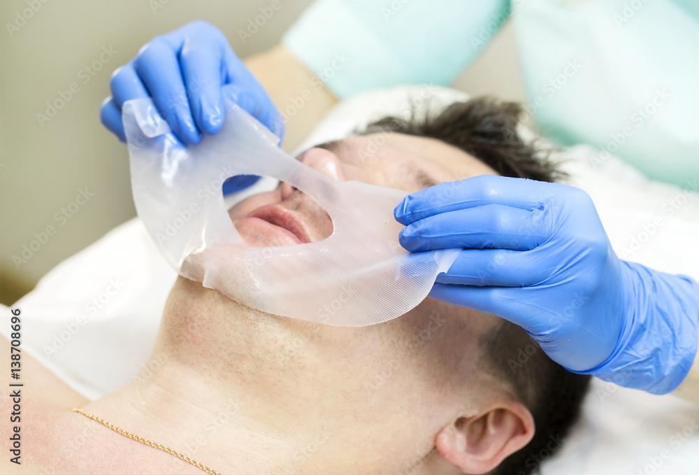 Man in the mask cosmetic procedure in spa salon Man in the mask cosmetic procedure in spa salon
