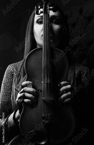 Girl holds a violin in hands. Black and white photo