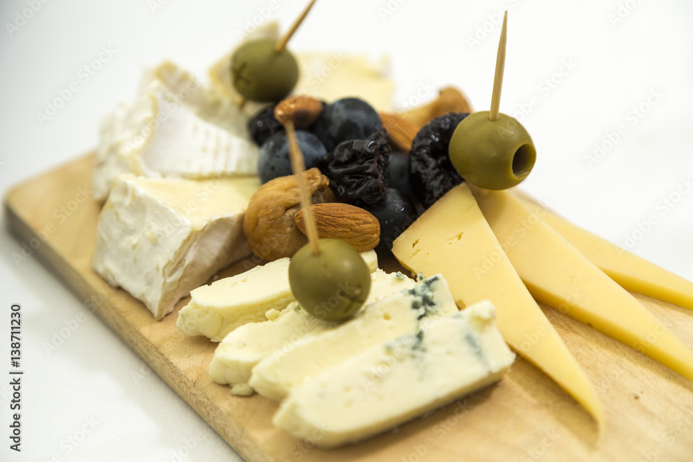 platter of cheese on a wooden board