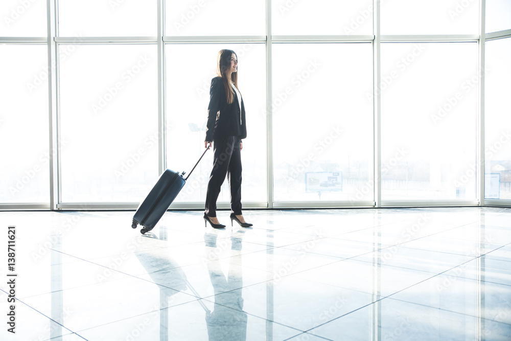 Business woman with laggage bag walking in airport Business woman with laggage bag walking in airport