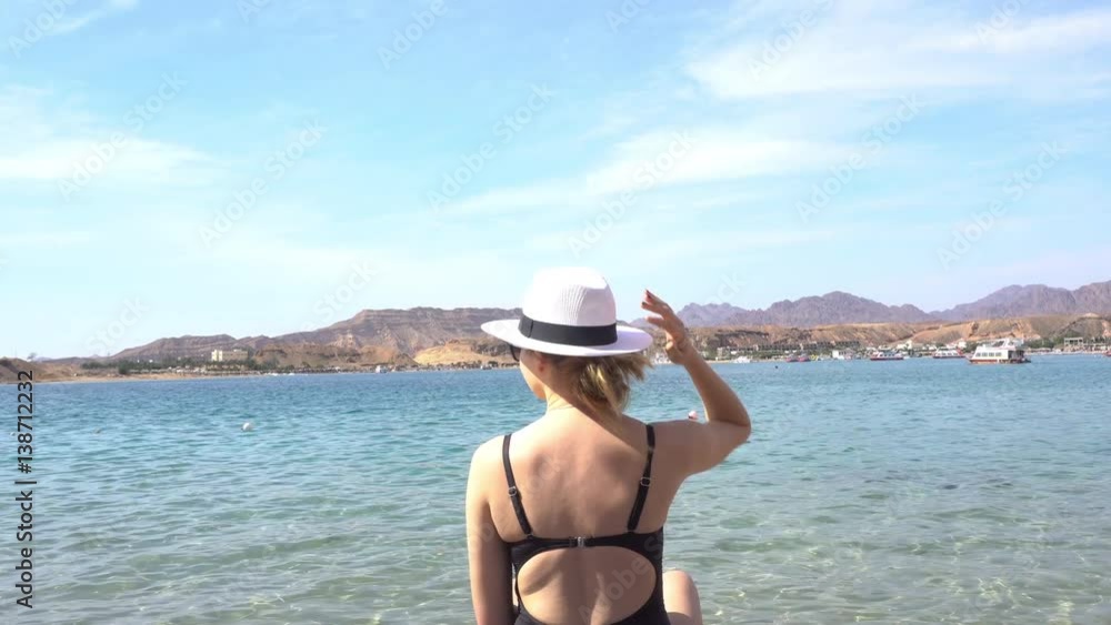 Female Puts on Hat While Standing Under the Sun Female Puts on Hat While Standing Under the Sun
