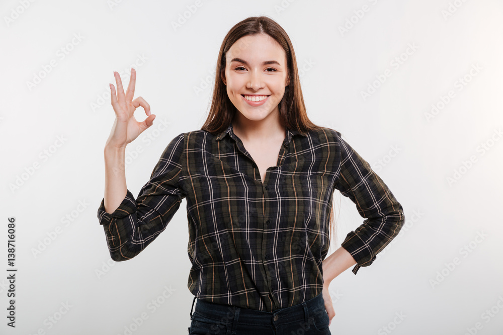 Smiling Woman in shirt showing ok sign Smiling Woman in shirt showing ok sign