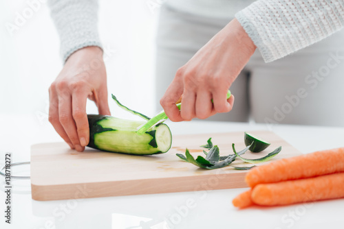 Woman peeling a cucumber