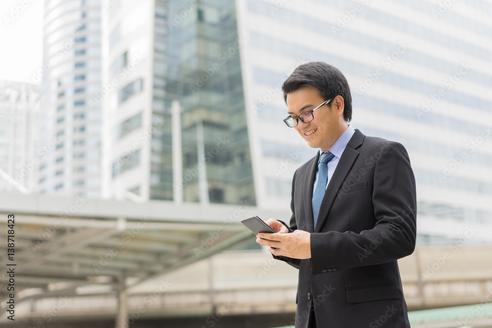 Young asian handsome businessman using smartphone with smiling Young asian handsome businessman using smartphone with smiling