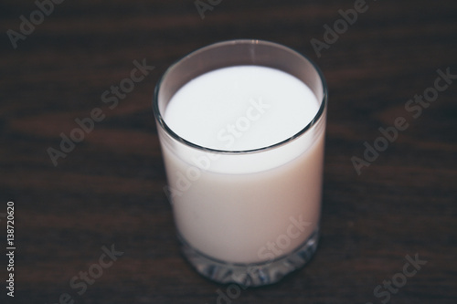 glass filled with milk on a wooden board