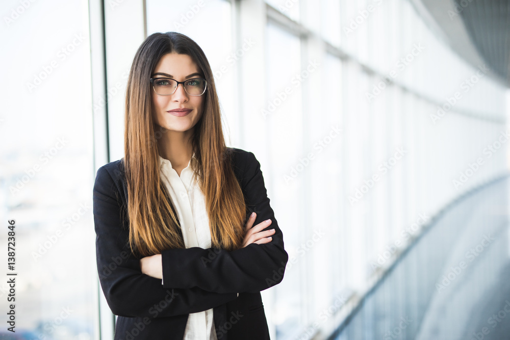 Businesswoman crossed hands portrait in office with panormic windows. Businesswoman crossed hands portrait in office with panormic windows.