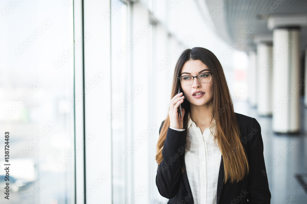 Young woman with mobile phone in the office Young woman with mobile phone in the office