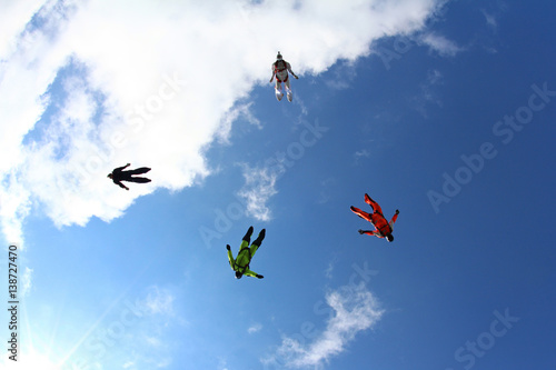 Skydivers are flying in the blue sky