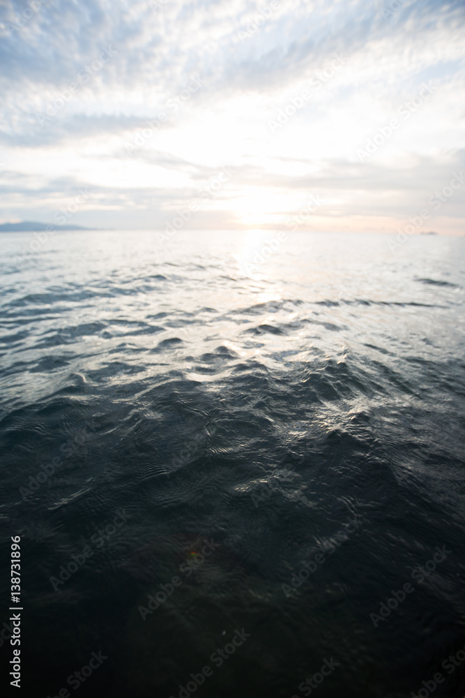 ocean wave splitted by waterline to sunset view