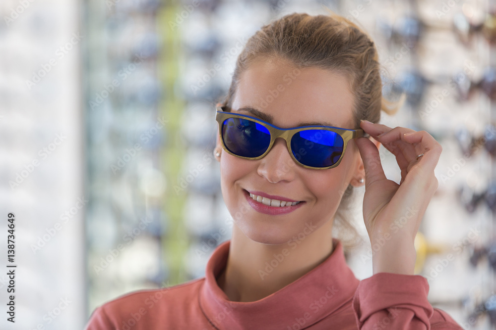 woman wearing sunglasses in optician shop woman wearing sunglasses in optician shop