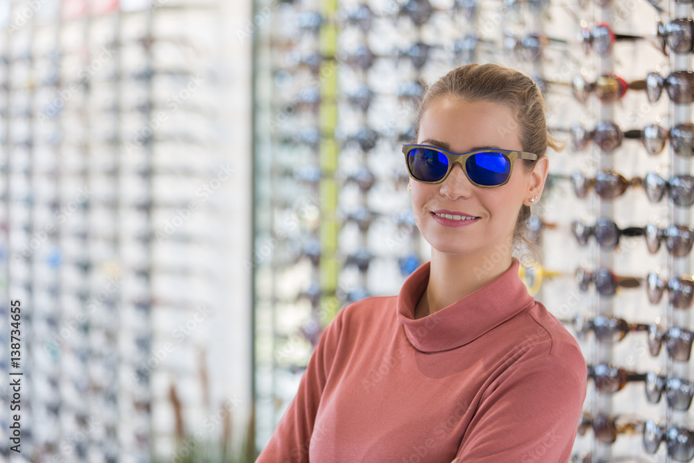 woman wearing sunglasses in optician shop woman wearing sunglasses in optician shop
