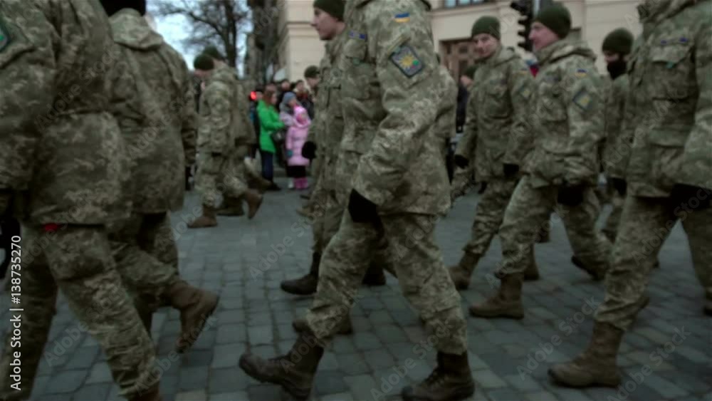 formation of soldiers in uniform marching on the pavement on the street formation of soldiers in uniform marching on the pavement on the street