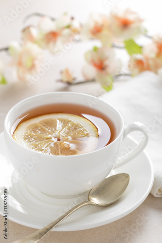 Cup of lemon tea on white background