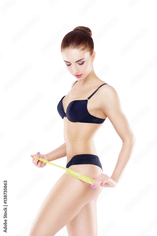 Fit, healthy and sporty woman in black swimsuit isolated on white. Beautiful girl measuring her body. Sport, fitness, diet, weight loss and healthcare concept. Fit, healthy and sporty woman in black swimsuit isolated on white. Beautiful girl measuring her body. Sport, fitness, diet, weight loss and healthcare concept.