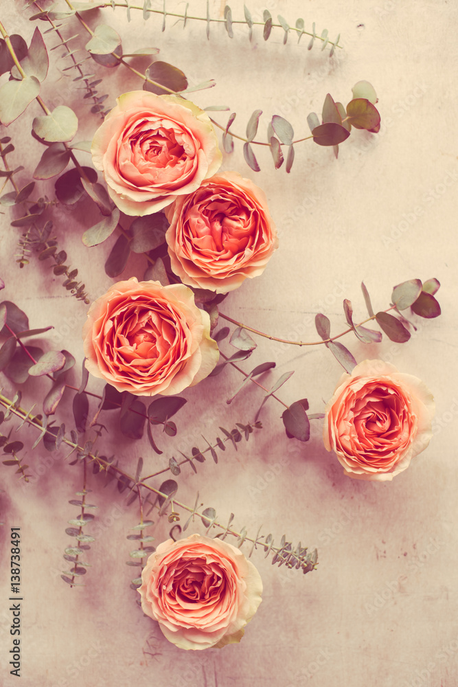 orange roses and decorative branches on white textured backgroun orange roses and decorative branches on white textured backgroun