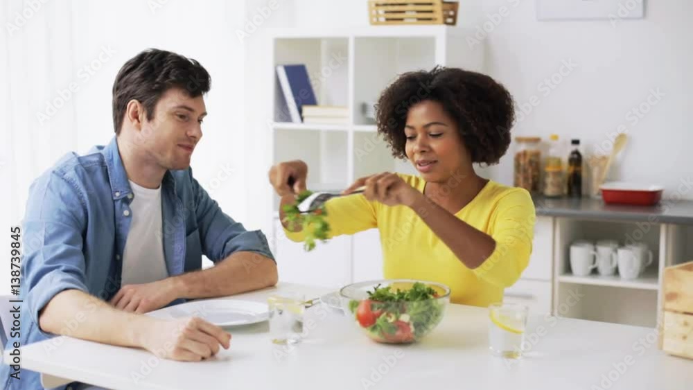 happy couple eating vegetable salad at home happy couple eating vegetable salad at home