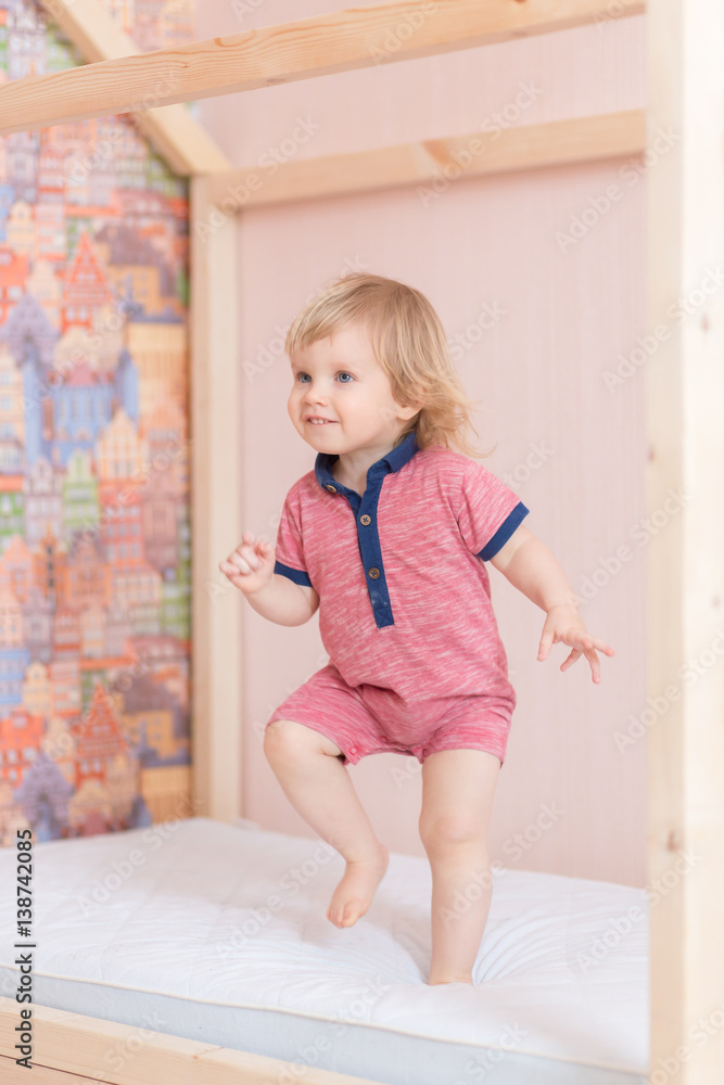 6 years old little boy is jumping on the parent's bed 6 years old little boy is jumping on the parent's bed