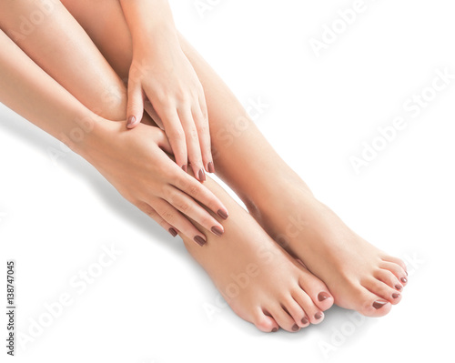 Female feet and hands with brown manicure on white background © Africa Studio