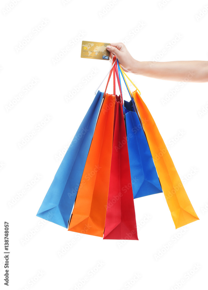 Woman holding shopping bags and credit card on white background