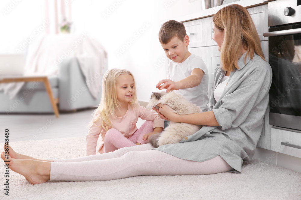 Mother and her children with cat at home Mother and her children with cat at home
