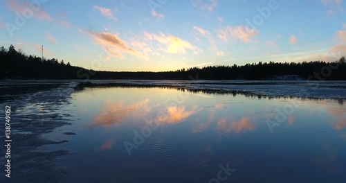 Wallpaper Mural Sunset sky mirroring on a lake, Cinema 4k aerial view of evening clouds mirroring on a icy lake, in siikajärvi, of Nuuksio national park, in Finland Torontodigital.ca