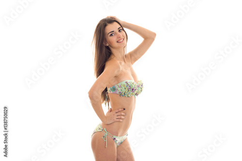 smiling sexy girl in a bathing suit is worth turning sideways and keeps a hand near hair