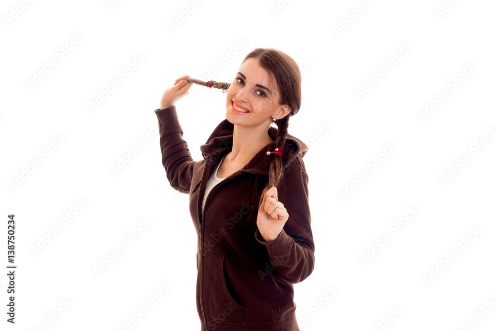 a teenage girl holds hands pigtails looks straight and smiling a teenage girl holds hands pigtails looks straight and smiling