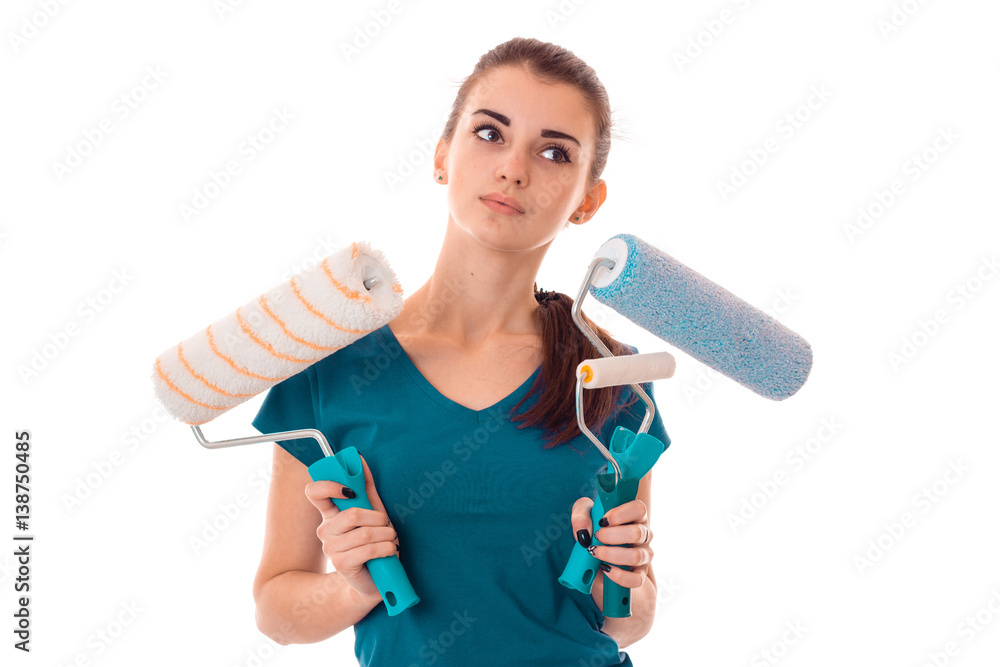 young brunette woman builder in uniform makes renovations with paint roller in her hands posing and looking aside isolated on white background young brunette woman builder in uniform makes renovations with paint roller in her hands posing and looking aside isolated on white background
