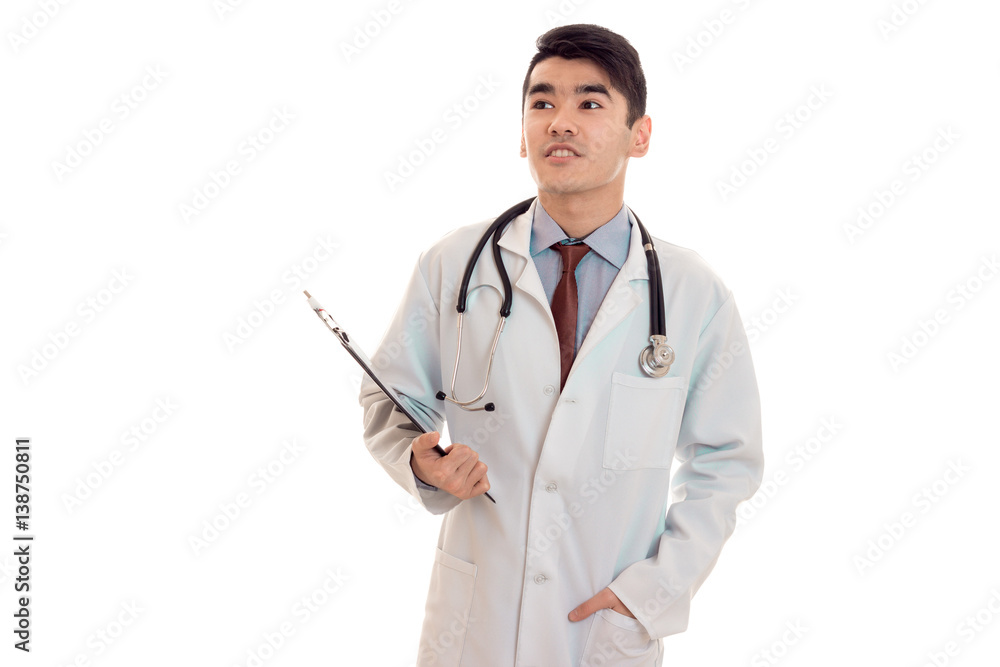 young male doctor in uniform with stethoscope on his neck looking away isolated on white background young male doctor in uniform with stethoscope on his neck looking away isolated on white background